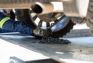 Tire Change 2 car being chained to flat bed tow turck